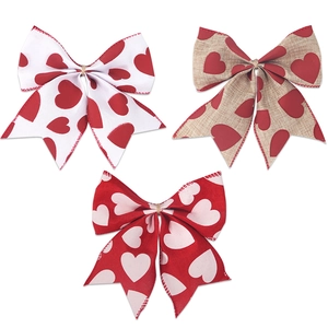Three Valentine's Day bows with red heart prints on white and linen fabric for party decor