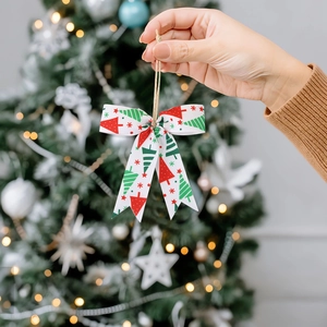 Mini Christmas ribbon bow with tree pattern and twine loop for festive holiday decoration