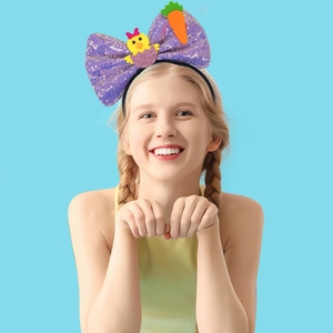 Easter sequin bow headband with yellow chick and carrot motifs worn by a smiling model