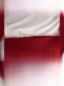 Close-up of festive red knit fabric with thick fleece lining and Santa Claus patch