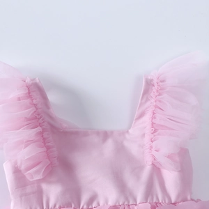 Close-up of pink baby girl dress featuring square neck and delicate tulle ruffled sleeves