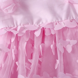 Detailed close-up of pink butterfly appliques with silver embroidery on layered tulle fabric