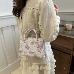 Sac cabas crème chic avec imprimés papillons roses vu de côté dans un intérieur chaleureux