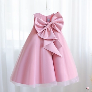 Detail of elegant dusty pink girls' gown featuring a large satin bow and layered tulle skirt