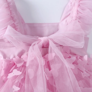 Detail of pink baby dress back featuring a large mesh bow and 3D butterfly appliqués