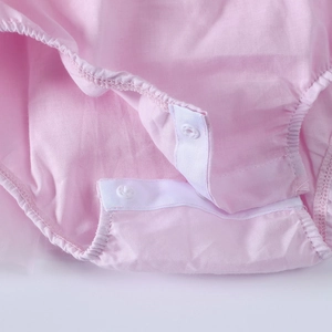Detail of baby bodysuit bottom with white snap fasteners for easy diaper changes