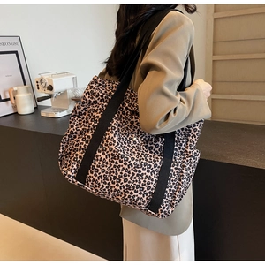 Détail d'un grand sac cabas à imprimé léopard avec d'épaisses bretelles noires solides
