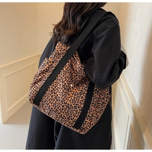 Vue détaillée du grand sac cabas léopard avec larges sangles noires porté par un mannequin