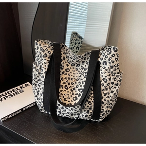 Détail d'un sac cabas en toile léopard avec poches latérales et bouton métallique