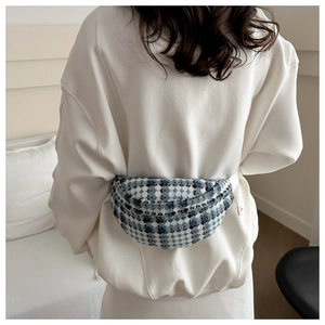 Detailweergave van de geruite tweed crossbodytas met witte verstelbare riem en rits