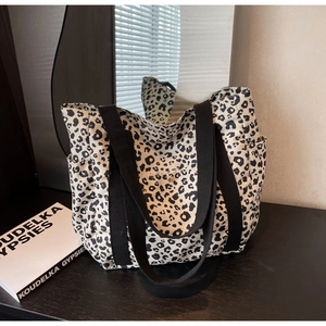 Détail du sac cabas en toile avec imprimé léopard noir et blanc et poche latérale pratique