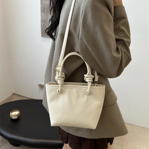 Chic beige leather bucket bag with knot handle detail for women's daily commute use