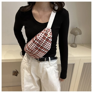 Detail van de rood-witte geblokte heuptas met riem en driehoekige ritssluiting
