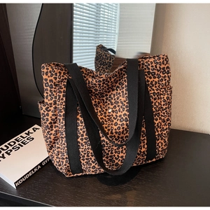 Gros plan d'un sac cabas en toile léopard avec poches latérales et anses en coton noir