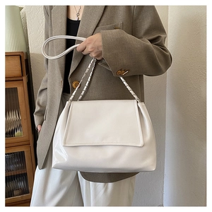 Sac à épaule en cuir blanc poli avec chaîne porté par un mannequin pour le quotidien