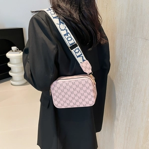 Pink minimalist crossbody bag with letter print and wide strap on model back view