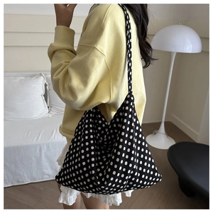 Polka dot canvas tote bag worn by a model in a minimalist minimalist home setting
