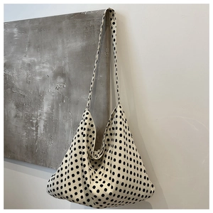 Detail of large capacity canvas tote bag with classic black and white polka dot pattern