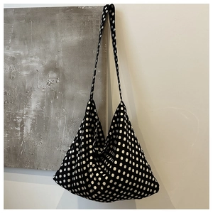 Close-up of black and white polka dot canvas tote bag with soft fabric texture