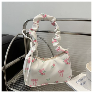 Detail van witte halvemaanvormige tas met roze rozenprint en scrunchie-stijl handvat