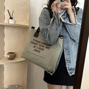 Sac cabas minimaliste en toile avec imprimé lettres et anses marron dans une pièce stylée