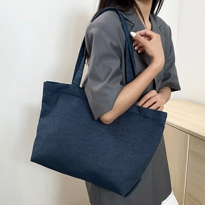 Minimalist large-capacity navy canvas tote bag carried by a model in casual style