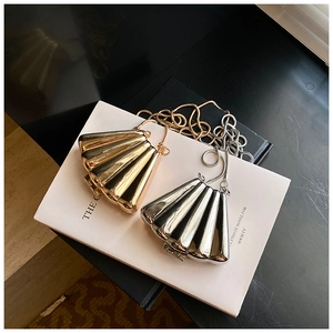 Detailed close-up of gold and silver shell-shaped metallic evening clutch bags with chain