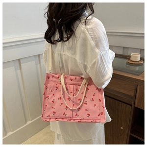 Vue arrière détaillée du sac cabas en toile rose à motif cerise avec bandoulière