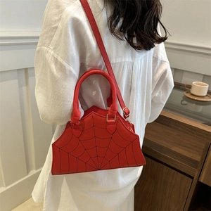 Red crossbody bag with black spider web pattern and adjustable shoulder strap