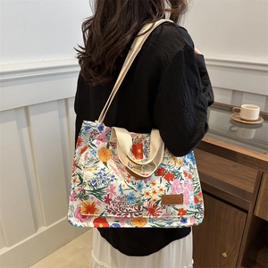 Floral canvas tote bag with adjustable strap shown in a cozy indoor lifestyle setting