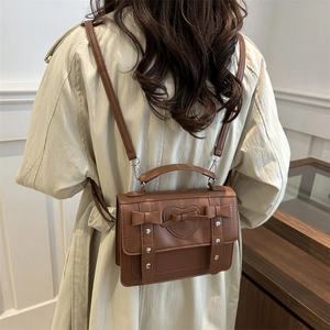 Mochila vintage de cuero sintético marrón con acolchado de corazón y lazos laterales