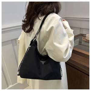 Detail of black nylon shoulder bag with silver triangle logo and metal chain strap