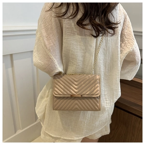 Detail of champagne gold quilted chain bag showing V-pattern texture and gold metal clasp