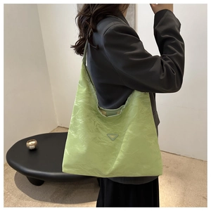 Detailed shot of mint green pleated nylon tote bag featuring a triangle fashion plaque