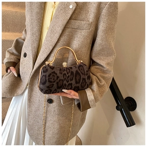 Detail of leopard print evening bag with curved gold handle and delicate chain strap