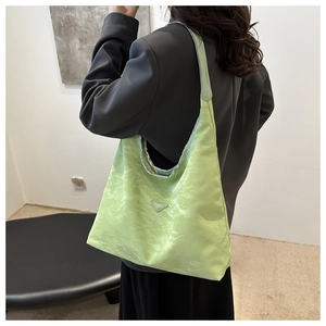 Detail of neon green tote bag with crinkled texture and metallic triangle logo