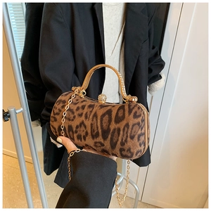 Detail of leopard print cylinder bag with crystal-encrusted gold handle and metal clasp