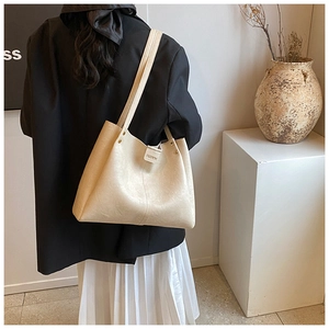 Detail of cream leather tote bag with FASHION label and retro rivet reinforcement