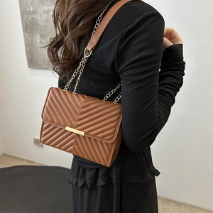 Brown quilted crossbody bag with golden chain strap and chevron pattern for women