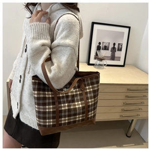Detailed close-up of brown checkered tote bag with embroidered dog patch and leather handles