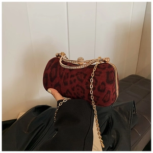 Detail der weinroten Samt-Clutch mit Leopardenmuster und goldenem Strassverschluss