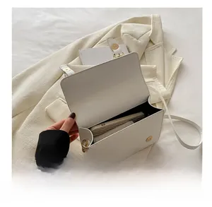 Internal view of a white minimalist shoulder bag showing storage capacity for essentials