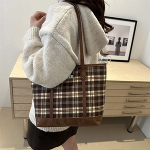 Brown checkered tote bag with puppy design and leather handles shown by model