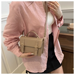 Detail of khaki retro crossbody bag with metal buckles and adjustable shoulder strap