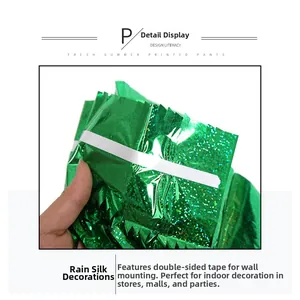 Detail view of green tinsel curtain showing adhesive tape for St. Patrick's Day party setup