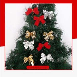 Fiocchi rossi floccati e metallici lucidi con lacci su rami verdi dell'albero di Natale