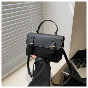 Detail of matte black leather crossbody bag with gold buckles and CHALFES & TIME logo