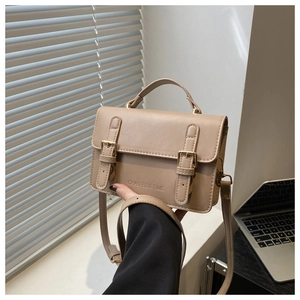 Detail showing beige crossbody bag with decorative straps and subtle embossed branding