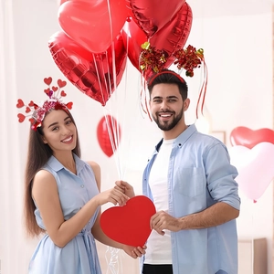 Détail d'un couple portant des serre-têtes cœur pailleté et guirlande pour la Saint-Valentin