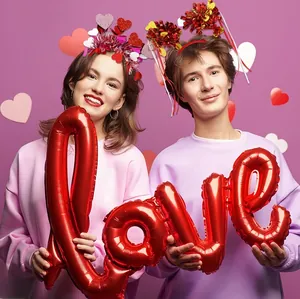 Couple portant des serre-têtes cœur de la Saint-Valentin avec glands et ballon LOVE